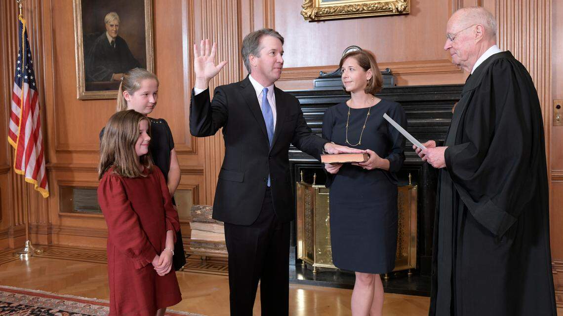 Retired Justice Anthony M. Kennedy, right, administers the Judicial Oath to Judge Brett Kavanaugh in the Justices’ Conference Room of the Supreme Court Building. Ashley Kavanaugh holds the Bible. At left are their daughters, Margaret, background, and Liza. (Fred Schilling/Collection of the Supreme Court of the United States via AP)