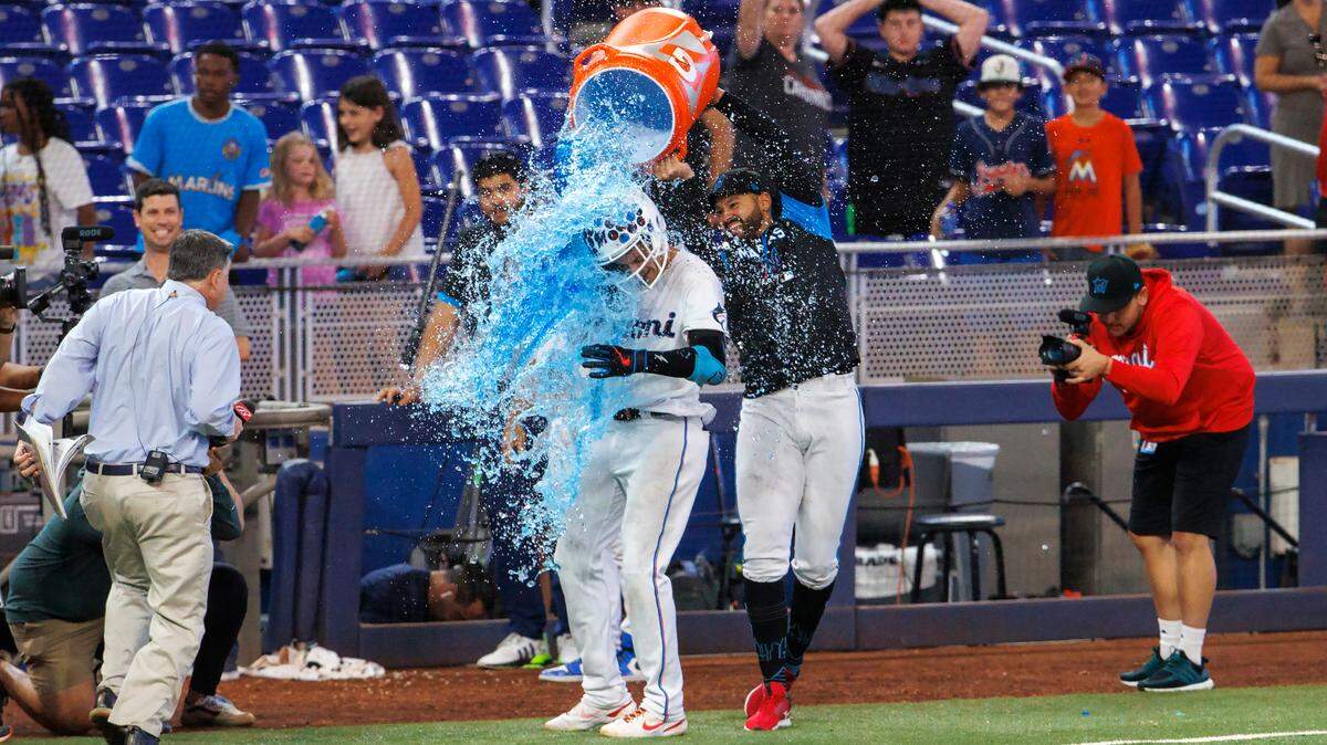 Miami Marlins second baseman Brian Anderson (15) got dump with a cooler of Gatorade by teammate Marlins starting pitcher Pablo Lopez (49) after hitting a two run walk-off triple during the eleventh inning of a baseball game against the Pittsburgh Pirates at LoanDepot Park on Thursday, July 14, 2022 in Miami, Florida.