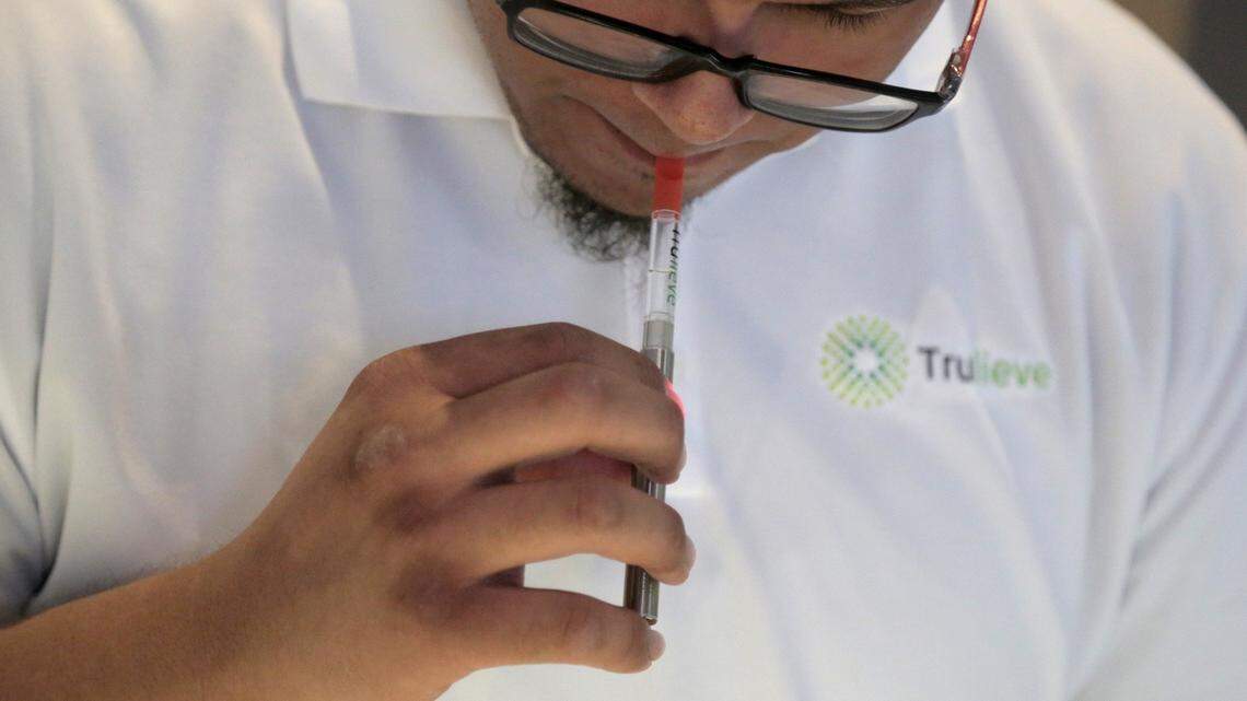 Miami, Florida, May 29, 2018 - Patient Consultant, David Montoya demos a vaporizer pen for a customer using a demo cartridge with no active ingredients at a South Florida grower/dispensary called Trulieve, 4020 NW 26th st. in Miami.