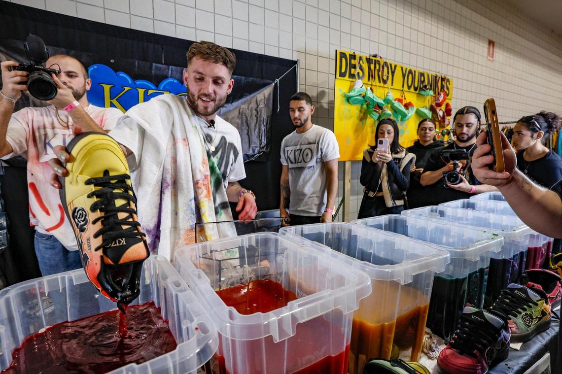 KIZO sneaker brand owner Jake Polino dips sneakers in a dye bath for Shareef O’Neal during Sneaker Con at the Broward County Convention Center in Fort Lauderdale, Florida, on Saturday, Jan. 11, 2025.