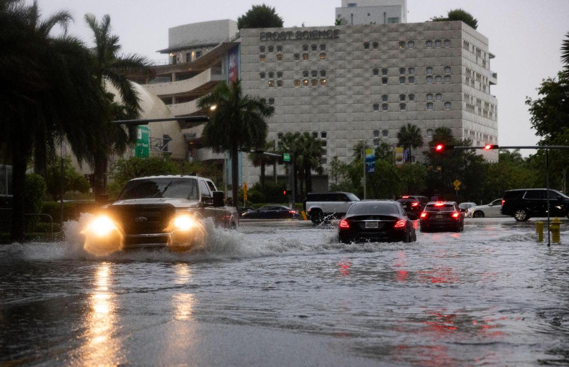 Cars drive down Northeast 11th Street during a flash flood warning on Monday, June 2, 2025, in downtown Miami, Fla.