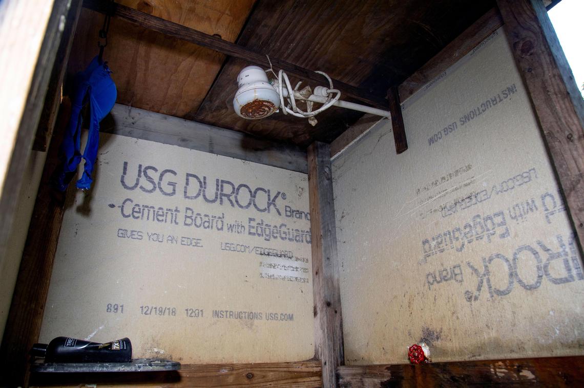 The only shower at a secret migrant camp in South Miami-Dade is surrounded by moldy wallboard.