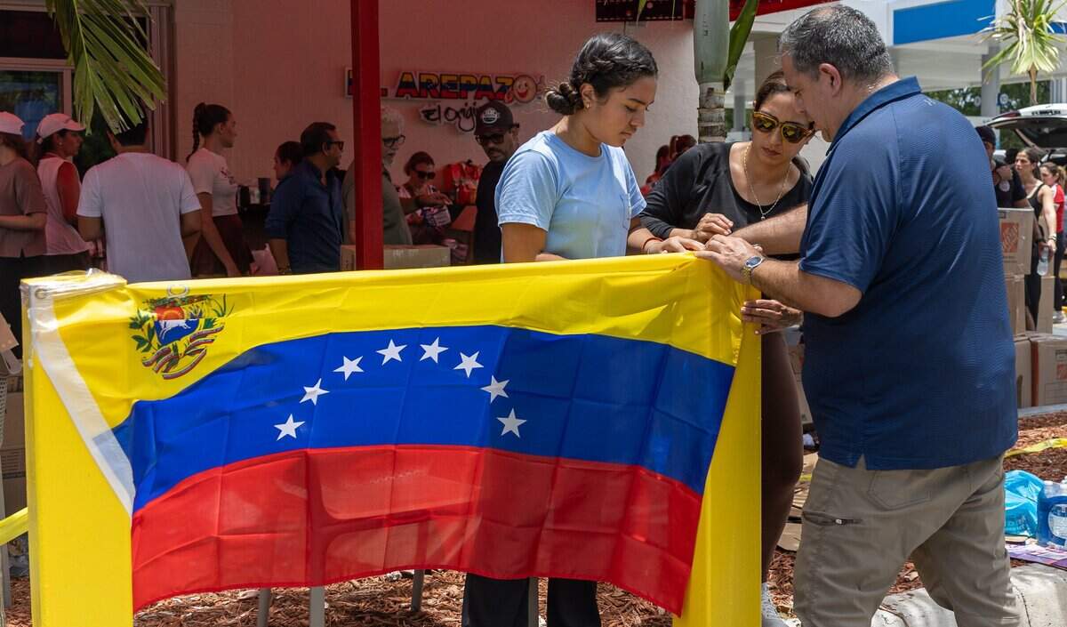 Volunteers tie a Venezuelan flag during a donation drive for Venezuelans affected by the earthquakes that hit the Caracas area Wednesday evening, at El Arepazo Restaurant in Doral, Fla., on Friday, June 26, 2026.