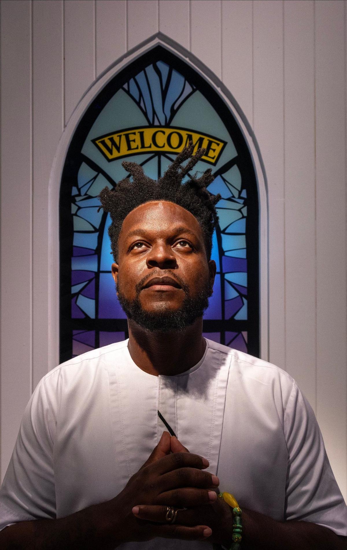 Woosler Delisfort stand near the faux stainless windows as he reconnects with the spiritual spaces of African,and Caribbean communities, and Miami’s Indigenous, by capturing moments of divine connection in temples, churches, mosques, and other spiritual spaces at the Historic Virginia Key Beach Park on Sunday, August 18, 2024, in Miami, Florida.