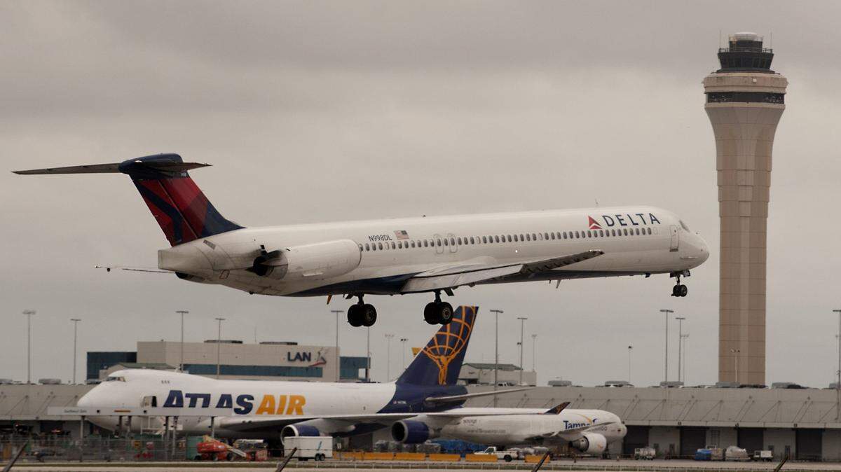 A Delta airlines jet lands in front of the Miami FAA tower at Miami International Airport on April 22, 2013.