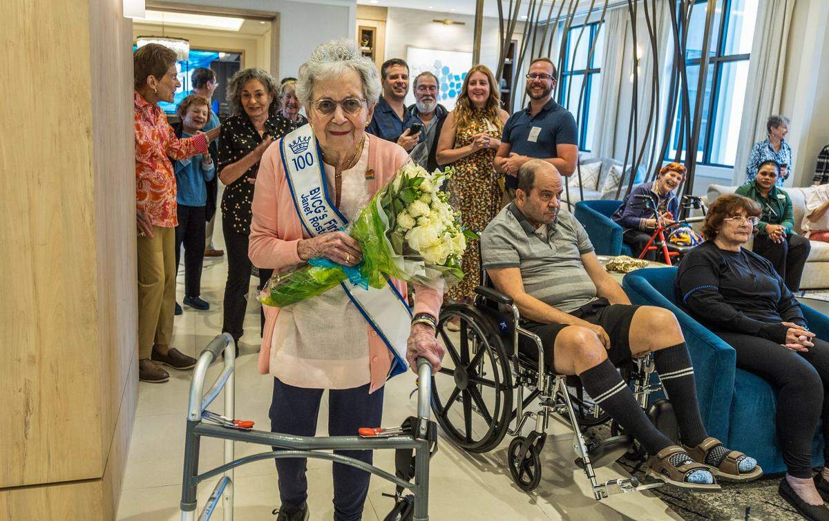 Janet Roston reacts as she enters to a surprise gathering to celebrate her 100th birthday with friends and family members at the Belmont Village community center in Coral Gables. She worked with Knight-Ridder, the former owner of the Miami Herald, and attributes her longevity to staying active both physically and mentally. on Friday September 27, 2024.