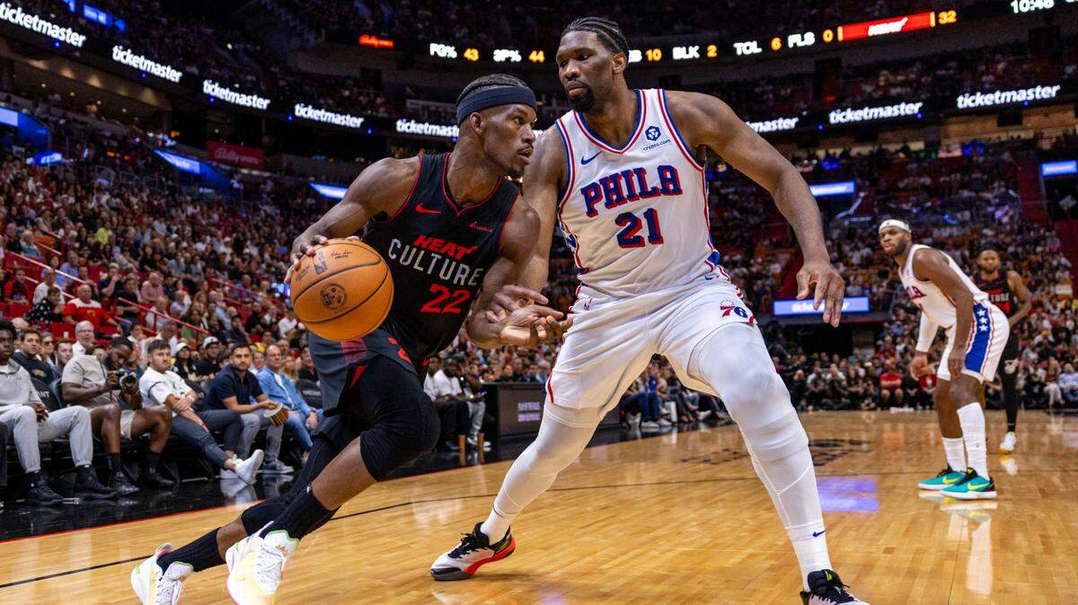 Miami Heat forward Jimmy Butler (22) drives on Philadelphia 76ers center Joel Embiid (21) during the first half of an NBA game at Kaseya Center in Miami, Florida, on Thursday, April 4, 2024.