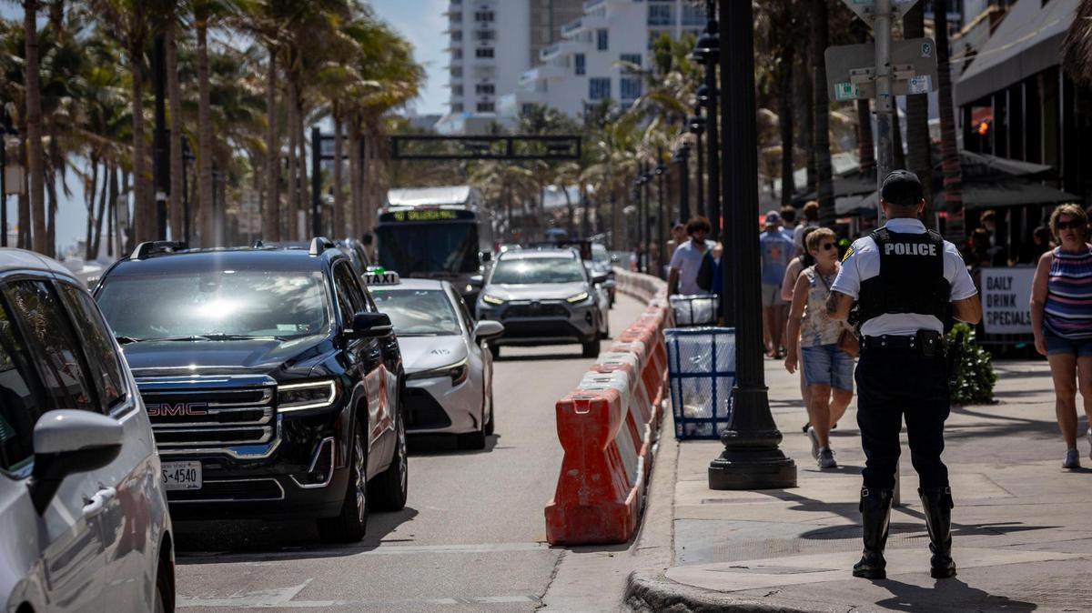 A Fort Lauderdale police officer, right, keeps an eye on traffic on A1A and Poinsettia Street on Fort Lauderdale Beach on Feb. 28, 2024.