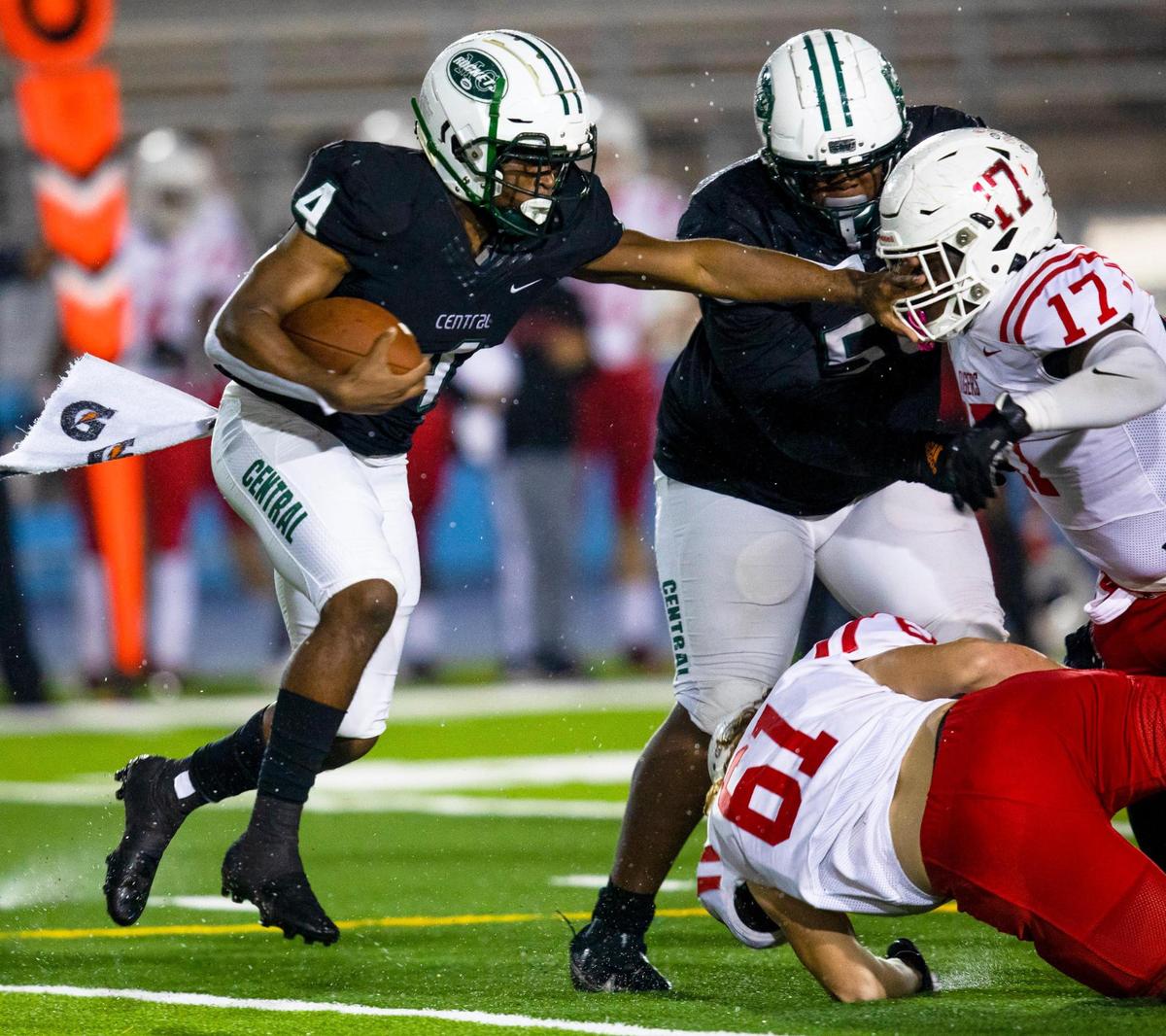 Miami Central High School running back Amari Daniels (4) stiff arms Palmetto Ft. Myers line backer Cedric Augustin as he runs down field during a Class 6A high school football state semifinal at Traz Powell Stadium in Miami, Florida, on Friday, December 11, 2020.