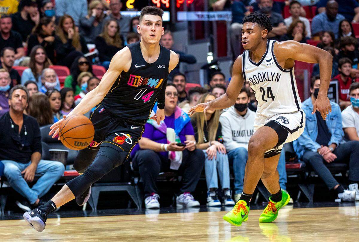 Miami Heat guard Tyler Herro (14) drives past Brooklyn Nets guard Cam Thomas (24) during the second quarter of an NBA game at FTX Arena in Miami on Saturday, February 12, 2022.