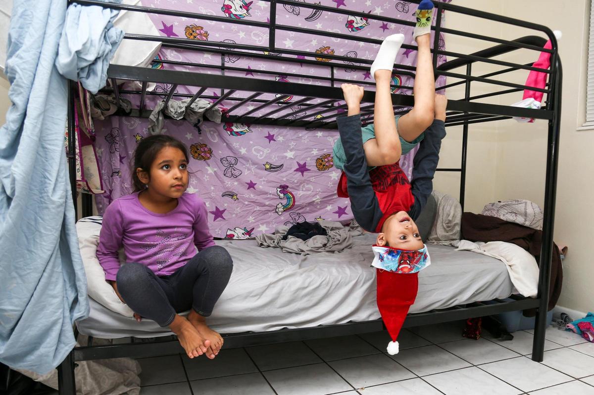 Janthony Santana, 6, and the youngest of his siblings, hangs out with his sister Janabella, 7, while they  watch TV.