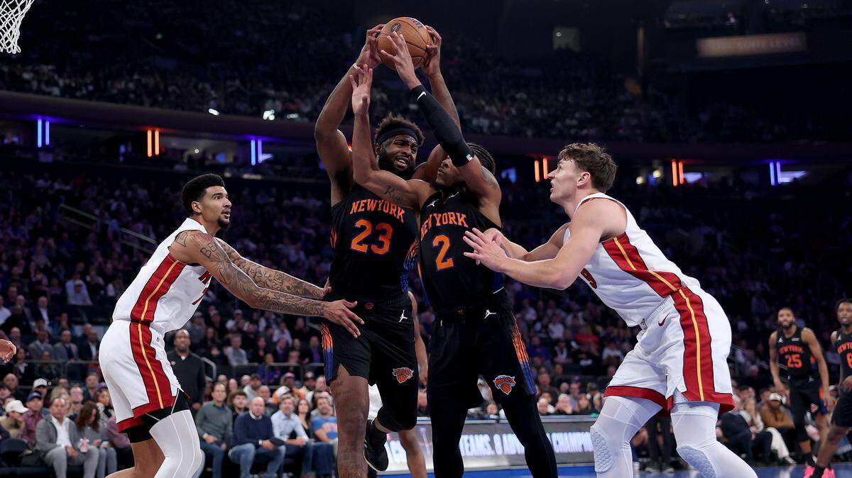 Mitchell Robinson #23 and Miles McBride #2 of the New York Knicks go after the rebound as Kel'el Ware #7 and Pelle Larsson #9 of the Miami Heat look on in the first half at Madison Square Garden on November 14, 2025 in New York City.