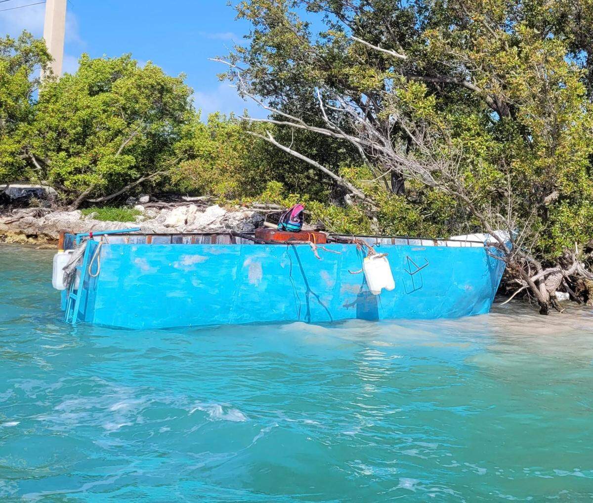 A blue wooden boat rests in the mangroves of Conch Key Wednesday, March 9, 2022. The Border Patrol said 29 migrants from Cuba were on board.