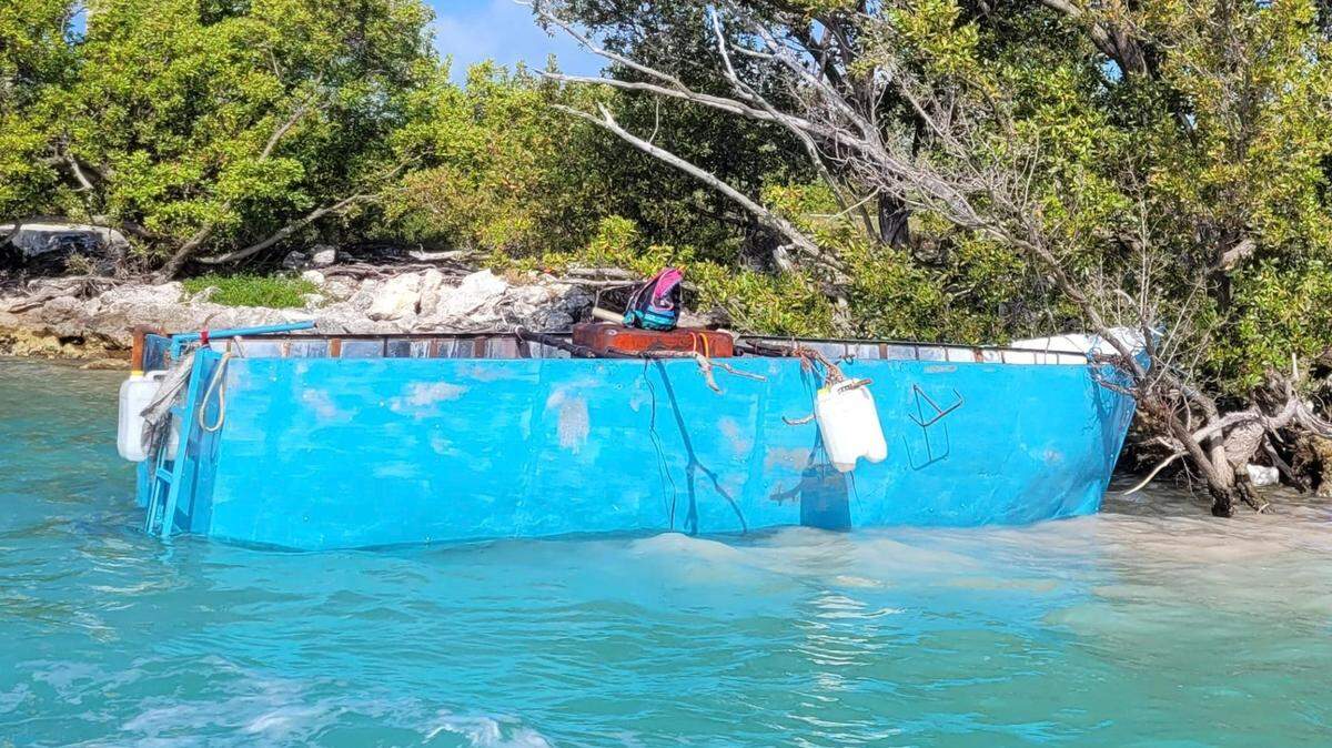 A blue wooden boat rests in the mangroves of Conch Key Wednesday, March 9, 2022. The Border Patrol said 29 migrants from Cuba were on board.