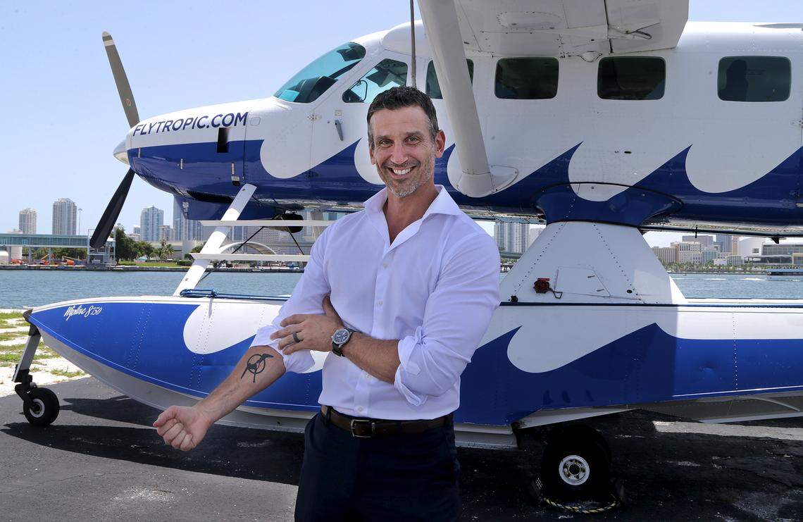Rob Ceravolo, CEO of Tropic Ocean Airways, displays a tattoo with the logo of his company while standing in front of a plane at the Miami Seaplane Base in Watson Island on Thursday June 20, 2019. The company was founded in 2009 and is providing first-class private charter and scheduled service flights throughout Florida and The Bahamas.