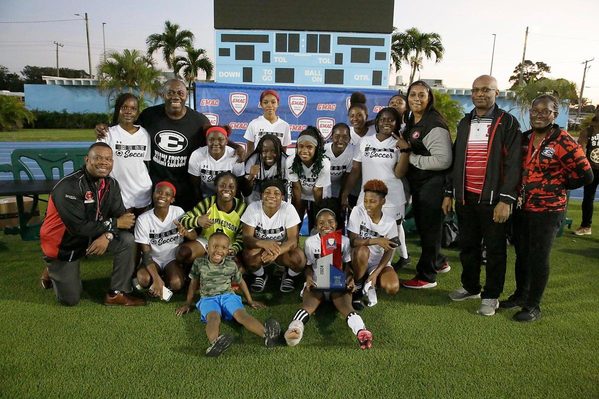 Miami Edison Red Raiders pose with the trophy after winning the GMAC girls’ soccer championship game against Palmetto on Friday.
