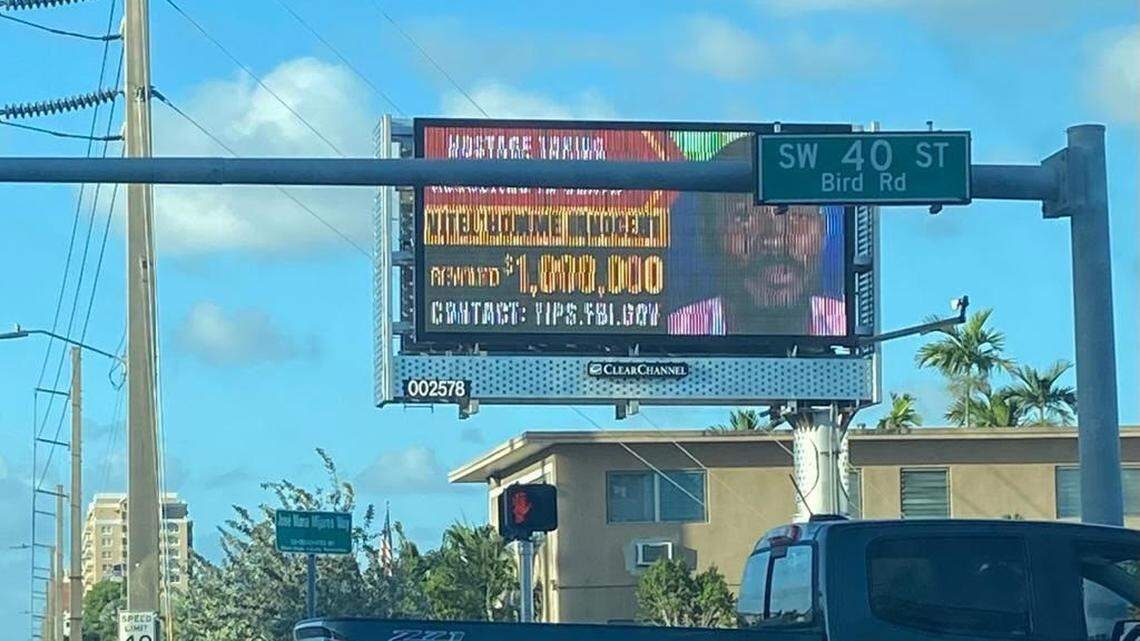 A billboard displayed on Bird Road Friday, Oct. 27, 2023, seeks information on the whereabouts of Haitian gang leader Vitel’homme Innocent.