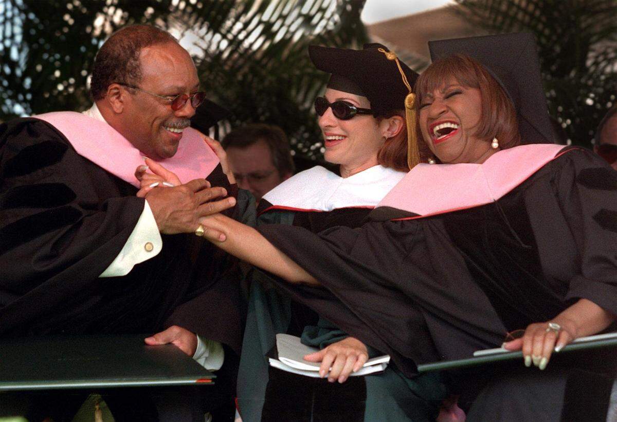 Quincy Jones and Celia Cruz celebrate after receiving honorary degrees at University of Miami’s graduation ceremonies as Gloria Estafan looks on in this archive photo from May 14, 1999.