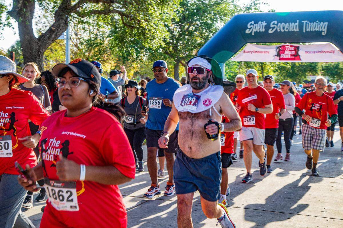Runners including Trevor Williams of Ohio, (wearing a nun’s habit), leave the starting line at the Barry University 5K/8K Nun Run on Saturday April 9, 2022.