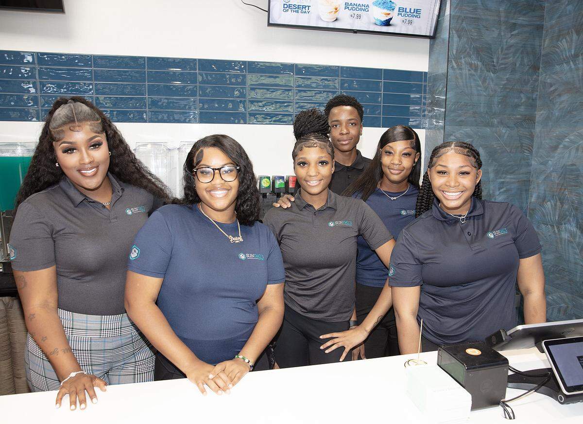 A group of empoyees, of  a new rapper Trick Daddy's  soul food restaurant Sunday's Eatery in Fort Lauderdale, pose for the pictur during the grand  opening on Saturday, August 30, 2025.  Andrew Uloza / for Miami Herald