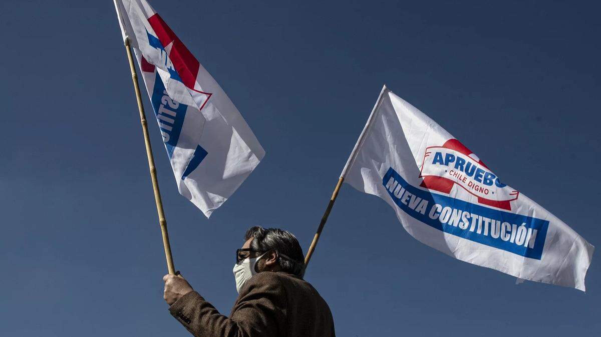 In 2020, a man waves flags in favor of the rewriting of the Chilean constitution to replace one dating back to the Pinochet dictatorship.