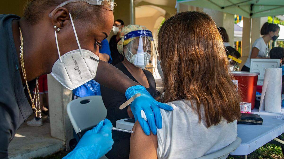A 14-year-old gets his first Pfizer COVID-19 vaccine shot from Nurse Erica Goodin at the South Miami Children’s Clinic on May 15. Florida has released its written guidance on COVID vaccine shots for children, which contradicts that from the Centers for Disease Control and Prevention.