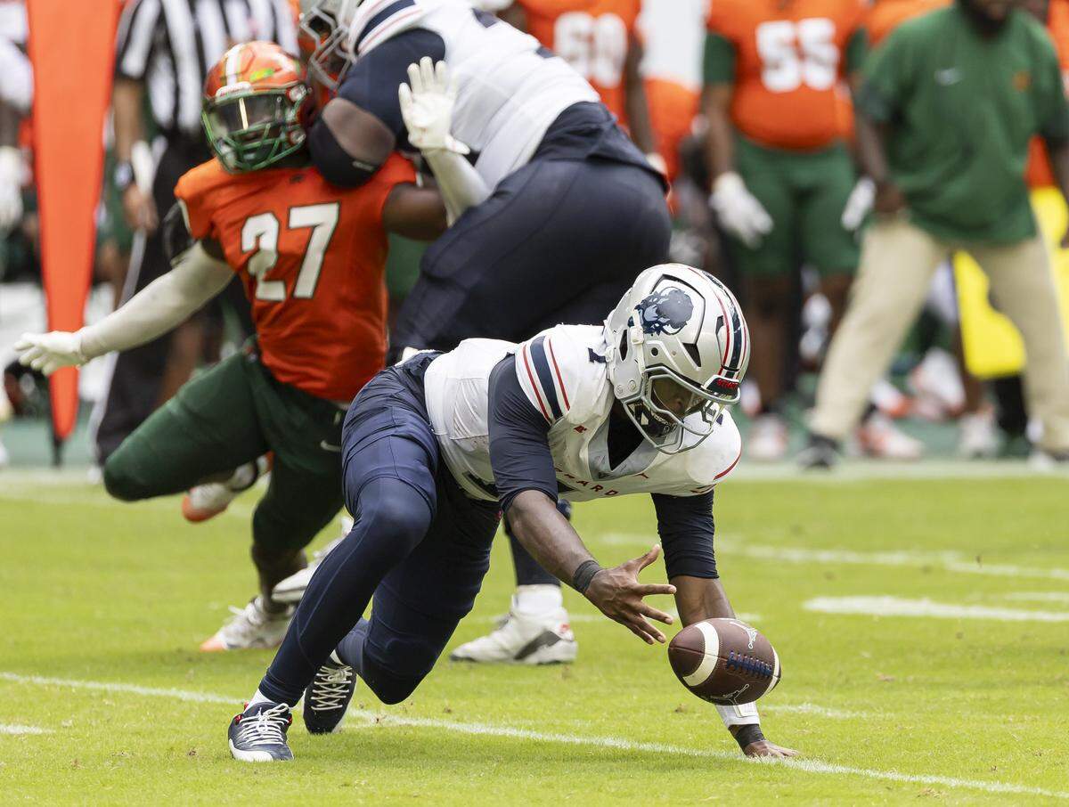 Howard Bison quarterback Tyriq Starks (1) recovers the ball as Florida A&M Rattlers linebacker Jason Riles (27) tries to tackle him in the first half of their Orange Blossom Classic football game at Hard Rock Stadium on Saturday, Aug. 30, 2025, in Miami Gardens, Fla.