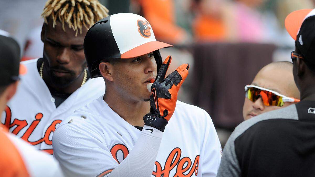 Manny Machado of the Baltimore Orioles celebrates with teammates after hitting a home run in the first inning against the Texas Rangers at Oriole Park at Camden Yards on July 15, 2018, in Baltimore, Maryland.