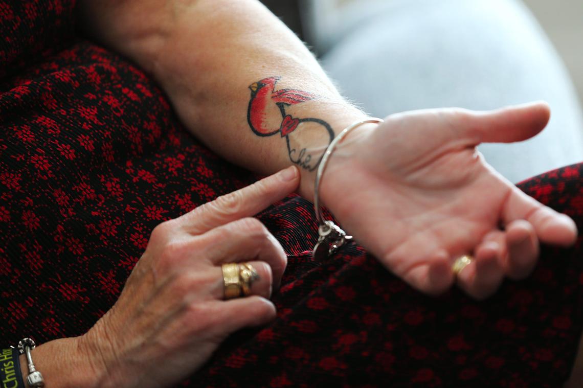 Debbi Hixon, wife of the late Chris Hixon, the athletic director and wrestling coach at Marjory Stoneman Douglas High, shows her tattoo of a cardinal on her forearm that she got in memory of Chris.