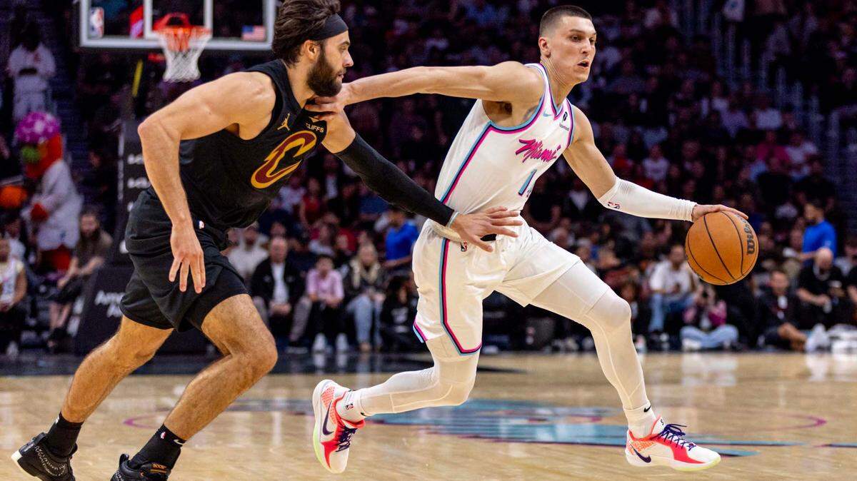 Miami Heat guard Tyler Herro (14) dribbles past Cleveland Cavaliers guard Max Strus (1) during the second half of an NBA game at Kaseya Center on Wednesday, January 29, 2025, in Miami, Fla.