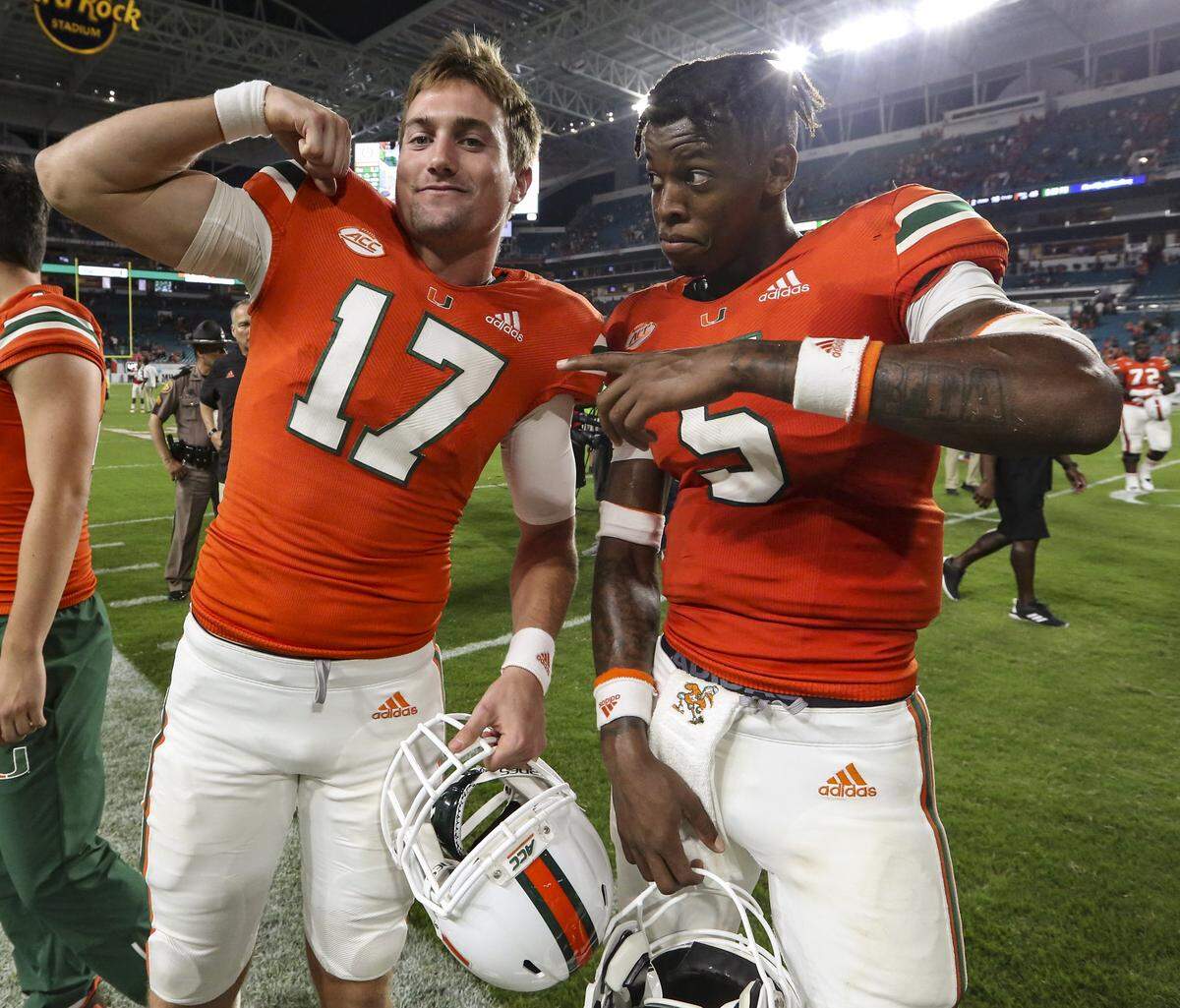Miami Hurricanes reserve quarterback Cade Weldon (17) and starting quarterback N’Kosi Perry (5) celebrate after defeating the Pittsburgh Panthers 24-3 at Hard Rock Stadium in Miami Gardens on Saturday, November 24, 2018.