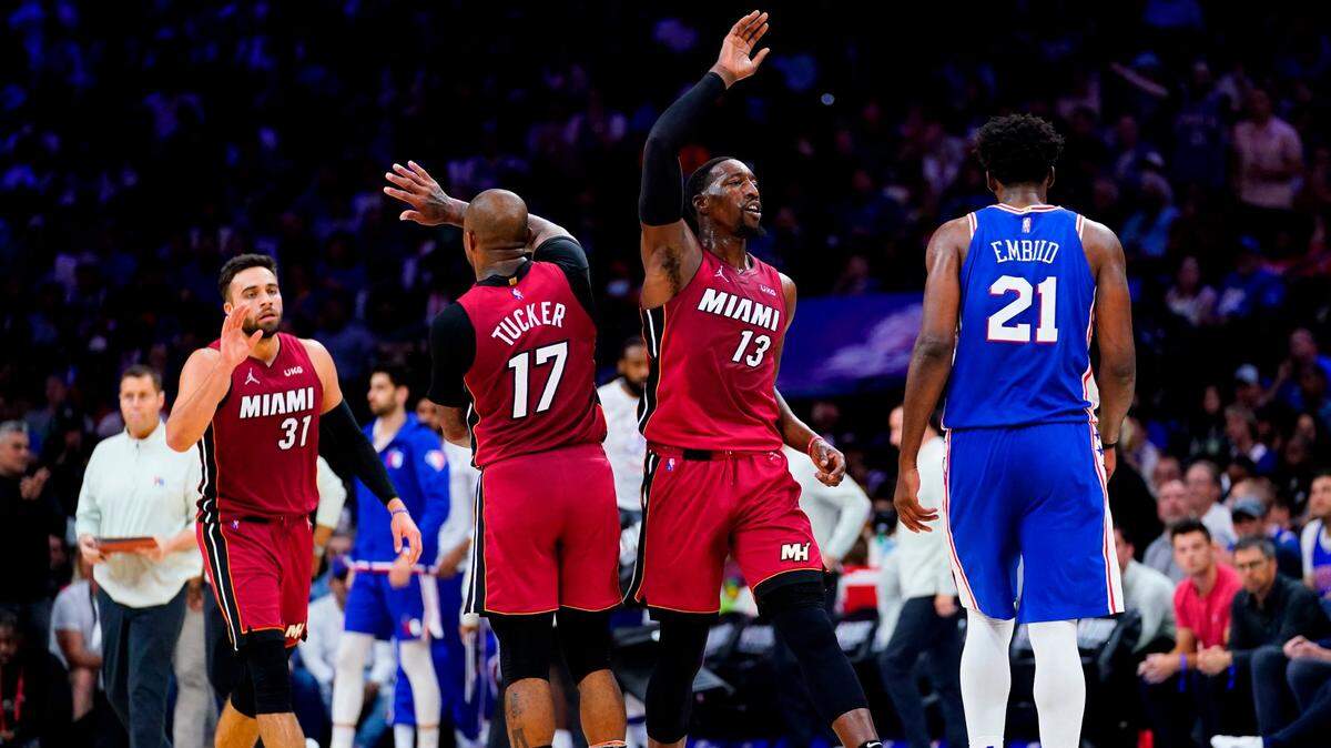 Miami Heat’s Bam Adebayo (13), P.J. Tucker (17), and Max Strus (31) celebrate past Philadelphia 76ers’ Joel Embiid (21) during the second half of Game 6 of an NBA basketball second-round playoff series, Thursday, May 12, 2022, in Philadelphia.