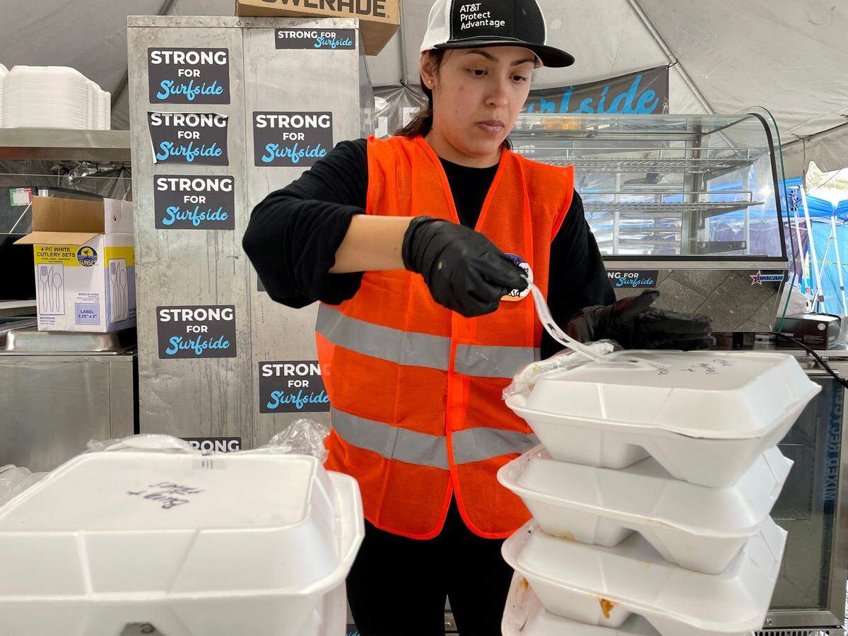 Vanessa Arrua seals every meal at the Surfside Community Center’s pop-up kitchen with a tape, certifying that the meals inside are kosher.