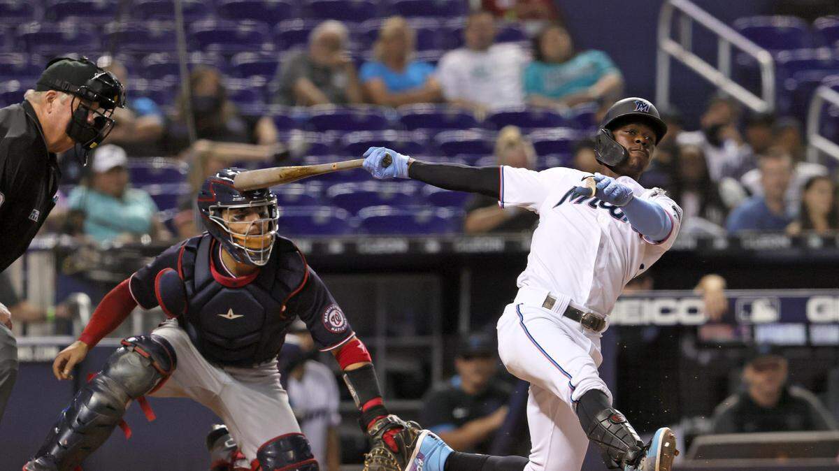Washington Nationals catcher Tres Barrera (38) looks on as Miami Marlins second baseman Jazz Chisholm Jr. (2) follows through on a foul ball during the eighth inning of their baseball game at loanDepot park on Thursday, August 26, 2021 in Miami, Florida.