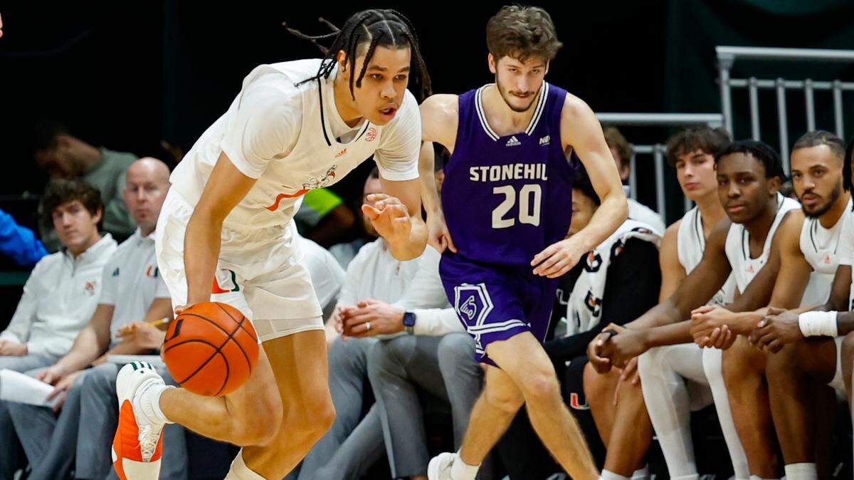 Miami Hurricanes guard Kyshawn George (7) drives the ball as Stonehill Skyhawks guard Nathan McGill (20) gives chase during the first half at the Watsco Center in Coral Gables, Florida on Thursday, December 21, 2023.