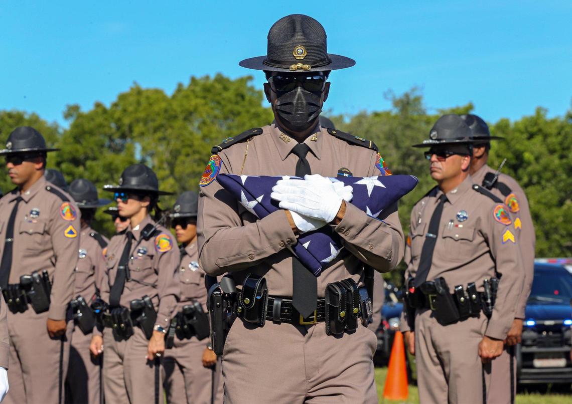 Florida Highway Patrol Captain James Edwards carries the American flag during the funeral service for Florida Highway Patrol Trooper Lazaro R. Febles at Woodlawn Park Cemetery in southwest Miami-Dade on Friday, Aug. 20, 2021. Febles, who served more than 11 years with the Florida Highway Patrol in Troop E Miami, died of complications from COVID-19.