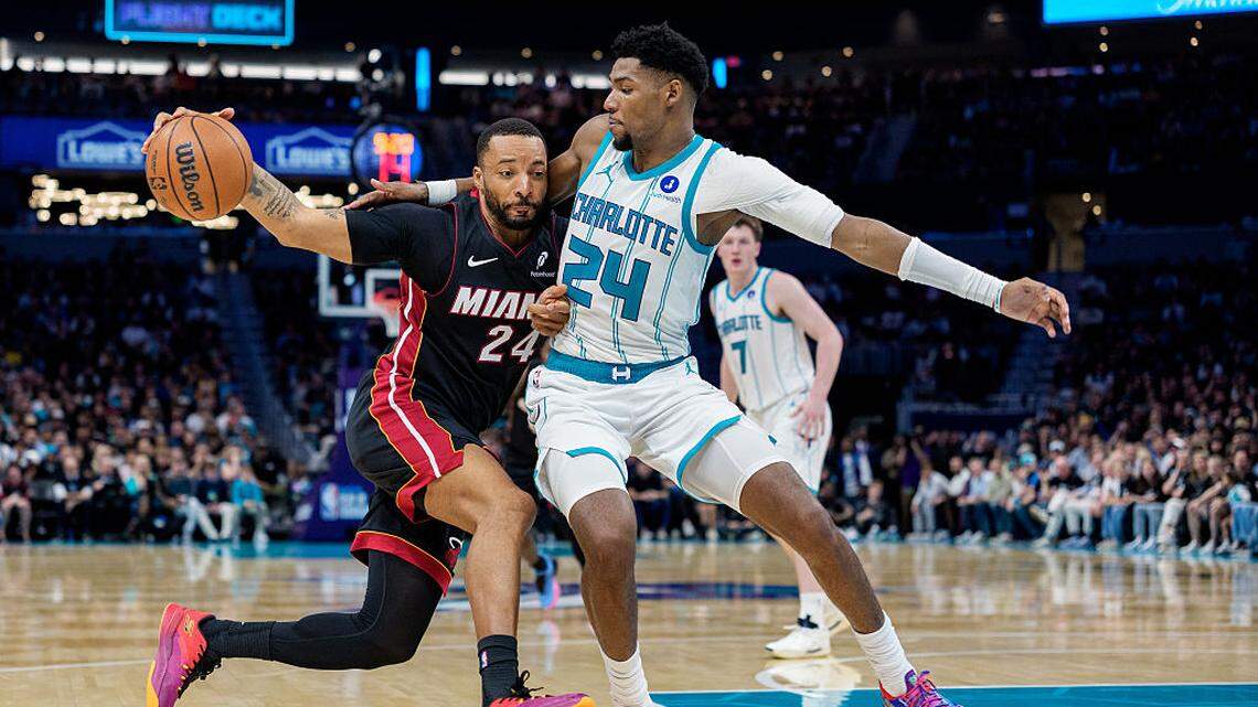 El escolta del Heat Norman Powell (izq.) entra al aro ante la marca de Brandon Mill, de los Hornets, en el partido del play-in celebrado el 14 de abril de 2026 en Charlotte.