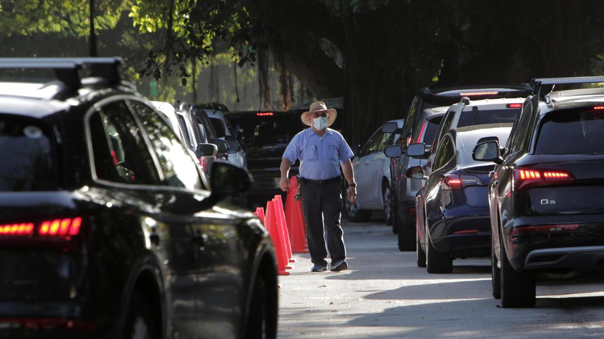 A security guard keeps cars moving in front of Sunset Elementary in Miami as parents drop off children at the school for in-person learning. All elementary students plus students in grades 6, 9 and 10 returned to Miami-Dade public schools Wednesday for in-person learning.