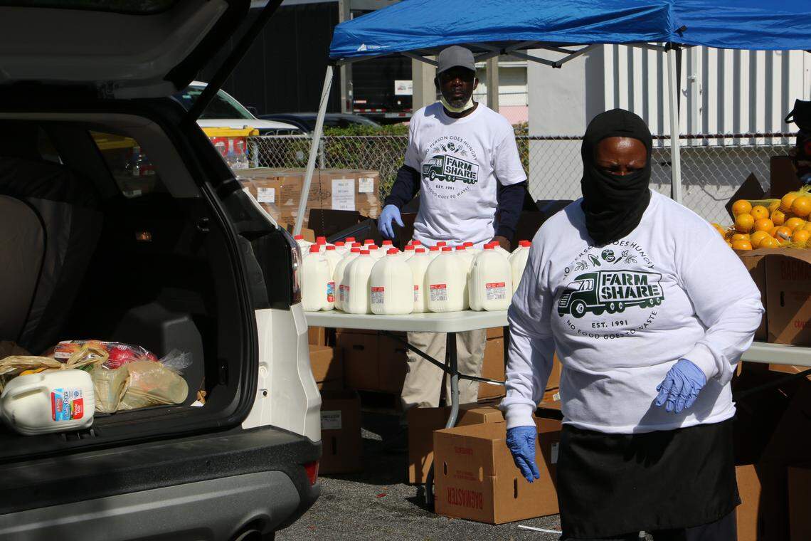 Farm Share volunteers place donated meals inside cars during a giveaway in Liberty City on March 25. Food pantries have been overwhelmed with fresh produce from Florida farmers who have had to dump their crops that went unsold because of the coronavirus crisis.