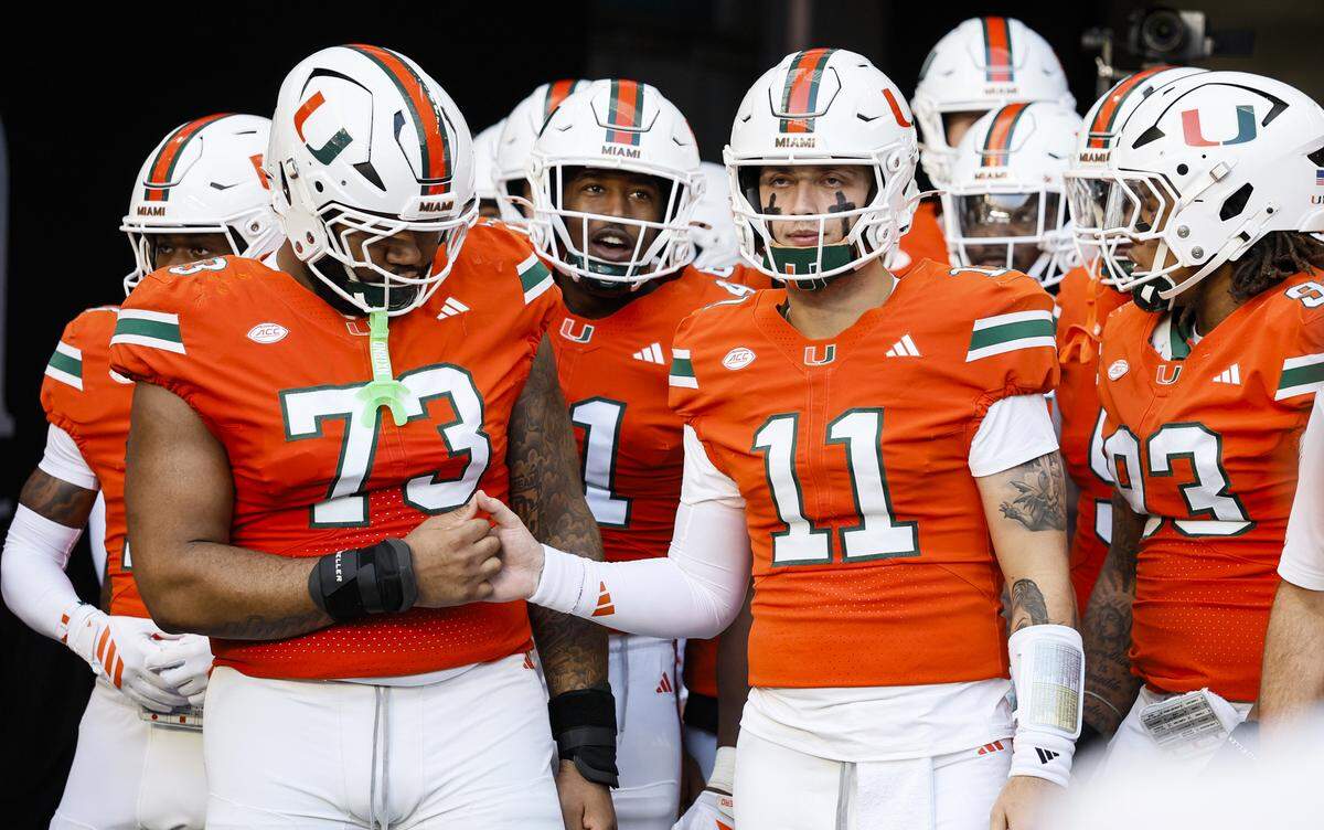 Miami Hurricanes quarterback Carson Beck (11) prepares to run out onto the field with teammates before the start of the NCAA game against the NC State Wolfpack at Hard Rock Stadium in Miami Gardens, Florida, on Saturday, November 15, 2025.