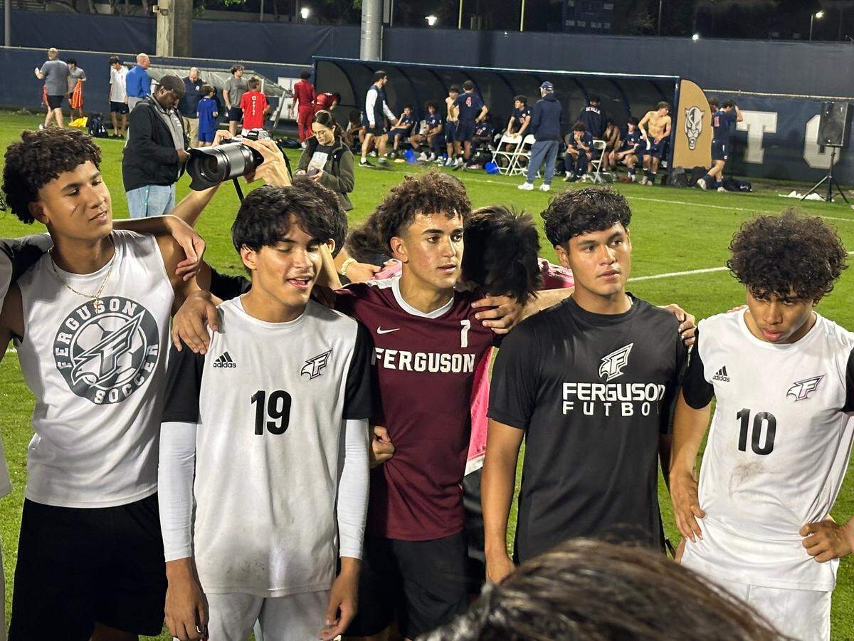 Ferguson goalkeeper Anthony Pasto (middle with burgundy jersey) listens to his coaches postgame after making two saves to help the Falcons beat Columbus in penalty kicks on Friday at FIU Soccer Stadium.