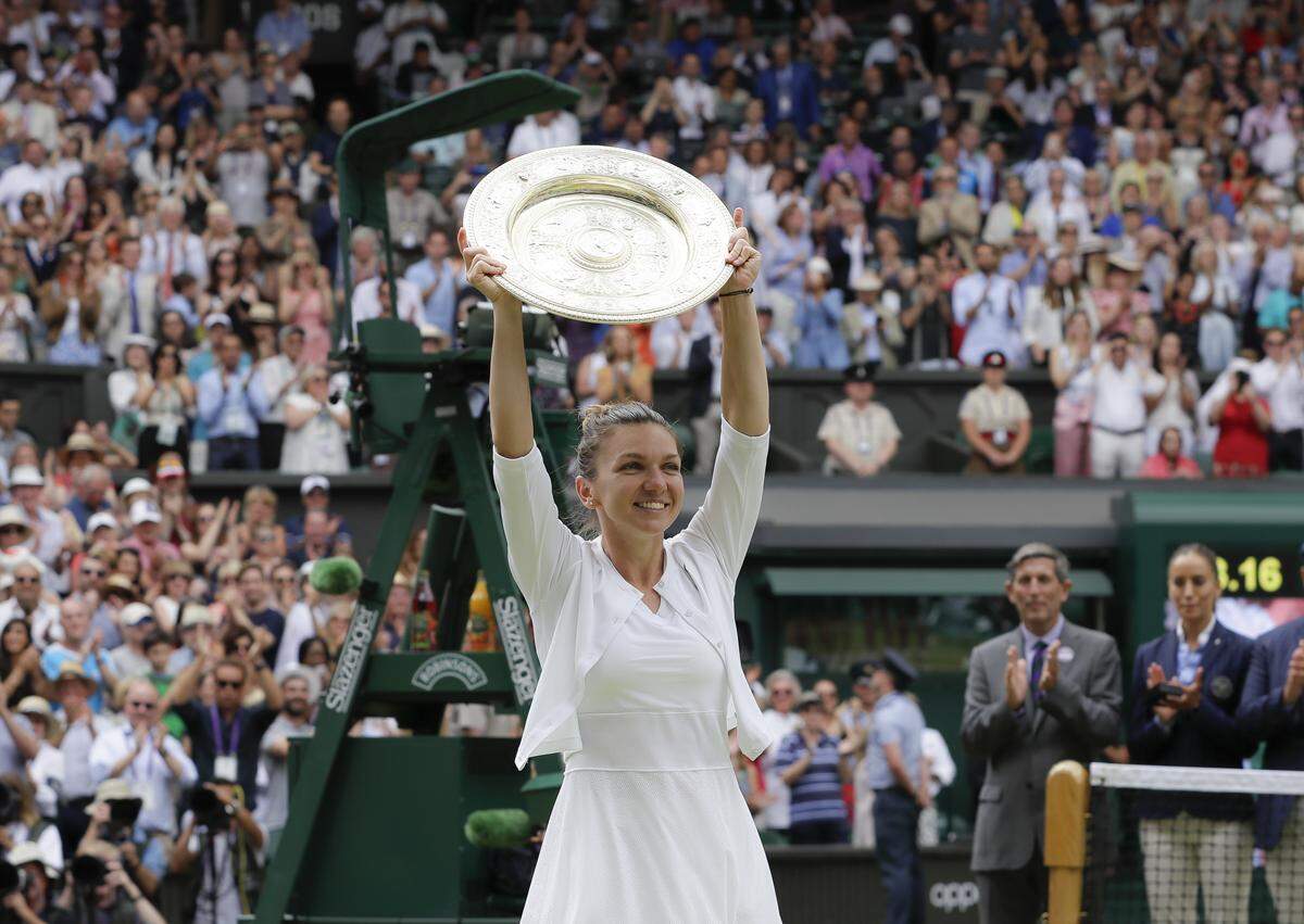 Romania’s Simona Halep holds the trophy after defeating United States’ Serena Williams during the women’s singles final match on day twelve of the Wimbledon Tennis Championships in London, Saturday, July 13, 2019. (AP Photo/Kirsty Wigglesworth)