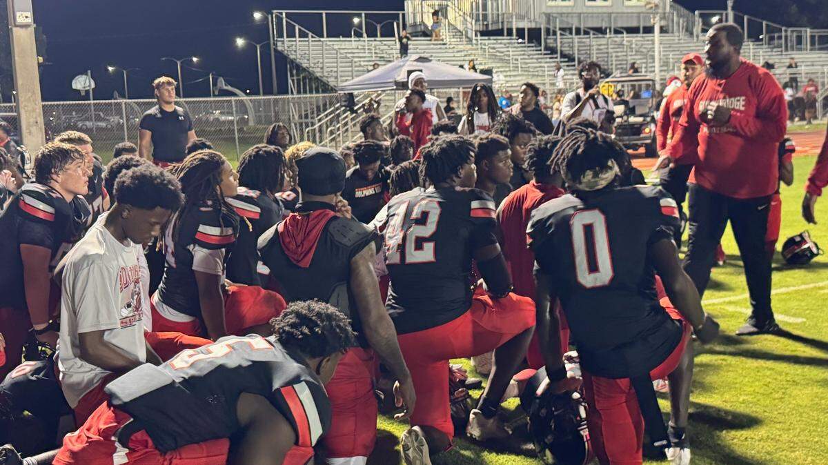 Southridge football coach Pierre Senatus (right) speaks to his players following Friday night’s 21-7 win over Palmetto at Southridge Stadium.