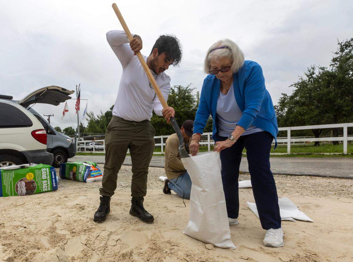 A Miami-Dade Parks and Recreation worker helped fill a sandbag for Yolanda Mas,  at Tropical Park last October as Hurricane Milton threatened South Florida. There are many companies that sell ‘sandless sandbags’ and other alternatives to reduce flood risks.  