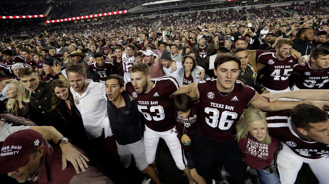 Students and fans join Texas A&M football players on the field after an NCAA college football game against LSU Saturday, Nov. 24, 2018, in College Station, Texas. Texas A&M won 74-72 seven overtimes.