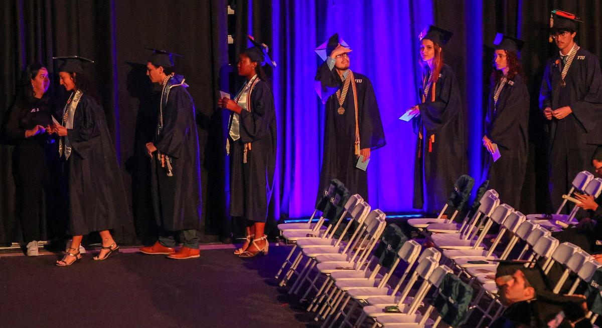 Students make a line, walking toward the stage.
