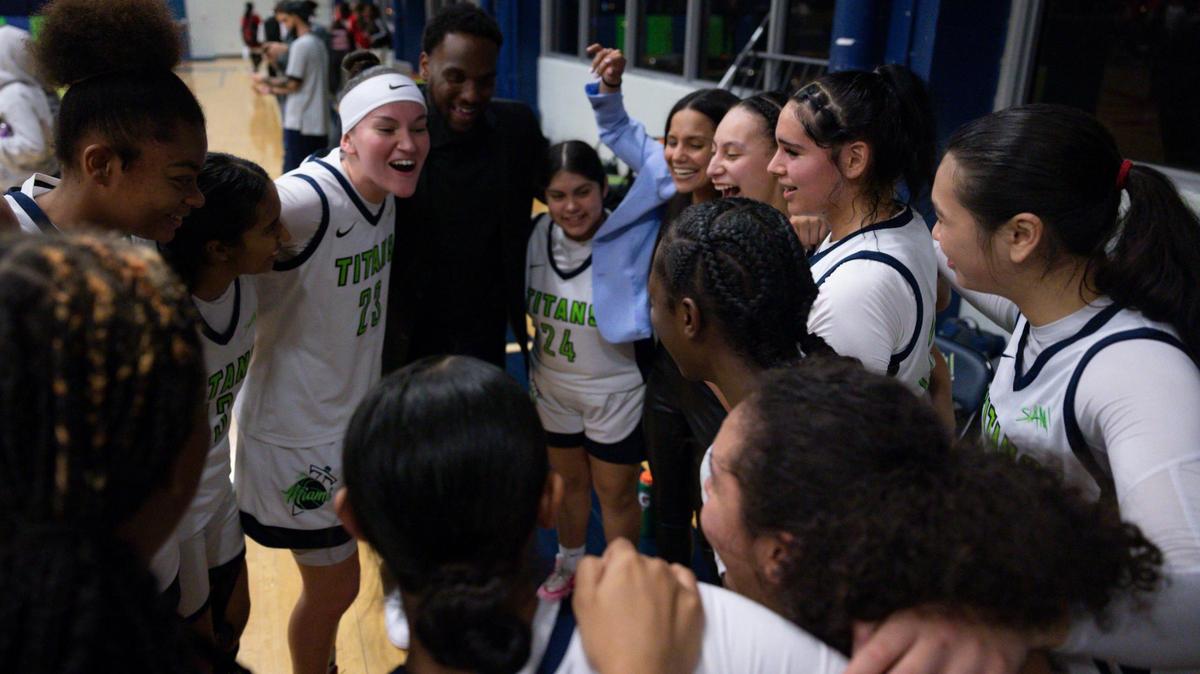 SLAM’s head coach Krystal Cabrera, center, and her team smile as they celebrate their win against Monsignor Pace during the girls basketball regional semifinal on Monday, Feb. 19, 2024, at SLAM Miami.