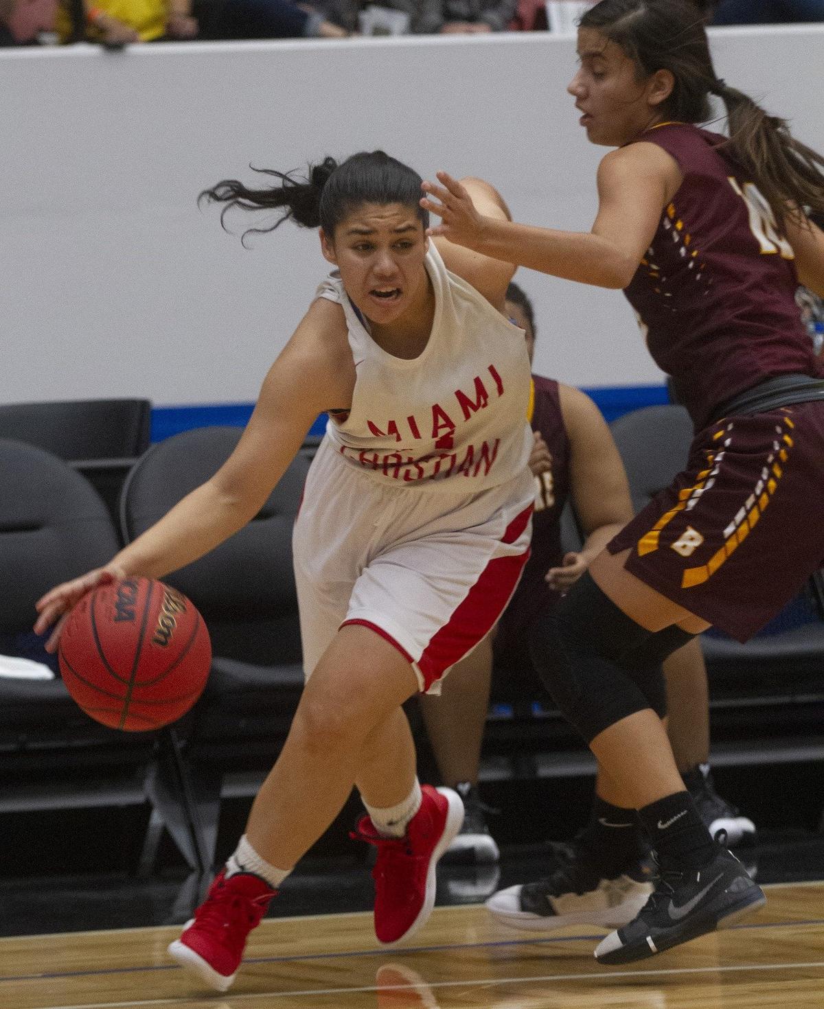 Miami Christian’s Gabriella Bendeck (14) drives under the basket as Bayshore Christian’s Fabiana Limongi (10) tries to defend during the first half of their FHSAA Girls 2-A Semifinal game at The RP Funding Center in Lakeland Monday. Miami Christian lost 53-50. February 25, 2019.