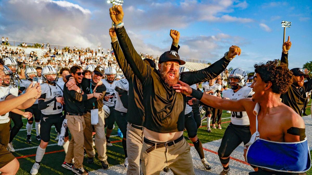 John A. Ferguson Senior High School football coach Gene Chew celebrates with players after the Falcons defeated G. Holmes Braddock Senior High at the GMAC independent schools championship at Tropical Park on Thursday, November 16, 2023.