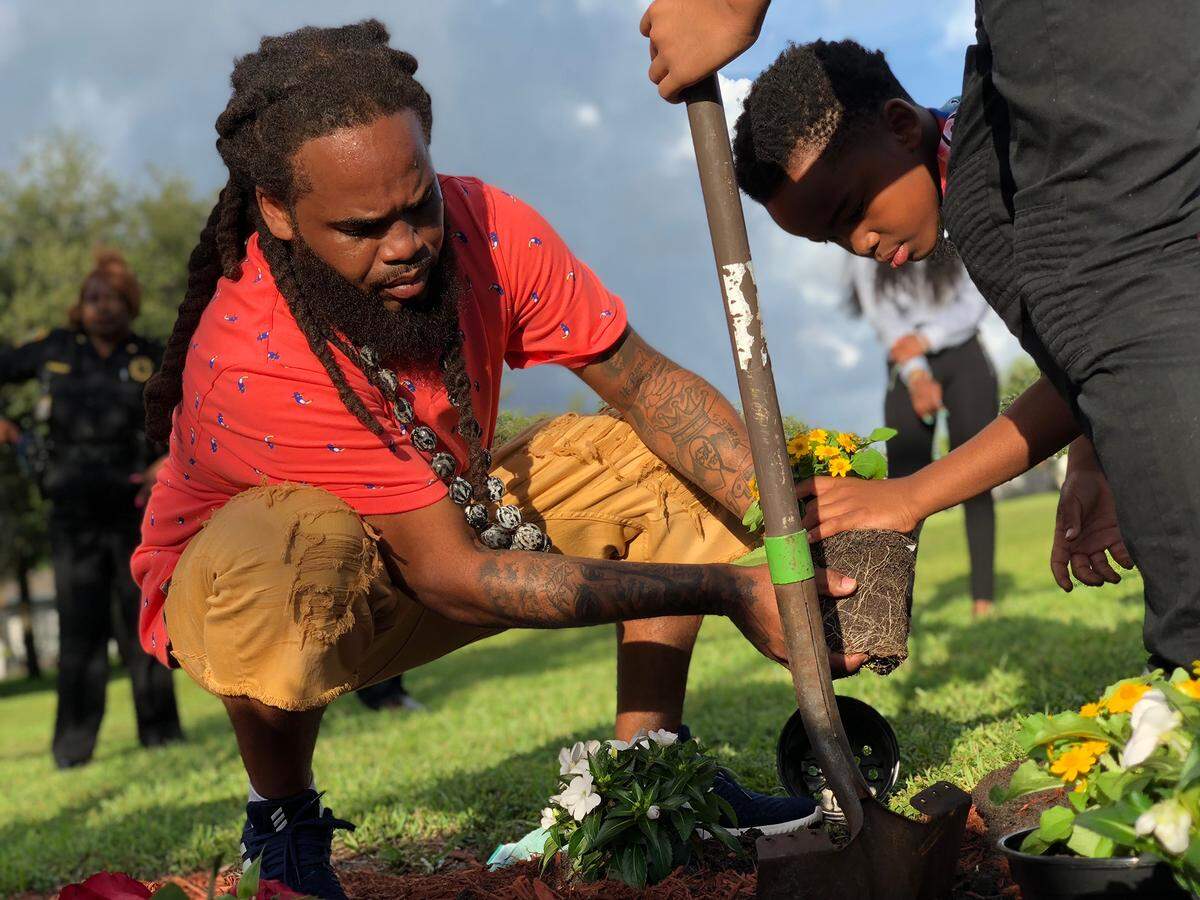 Glenn Forshee, the father of Tequila Forshee, plants flowers at a memorial for his daughter, who would have turned 18 on Sept. 24, 2018. She was killed in a shooting in 2013 in Miami Gardens.
